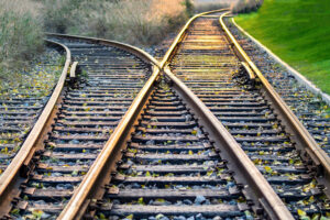 Railroad tracks diverging, the cover image for The Decision Kept Moving While We Built It