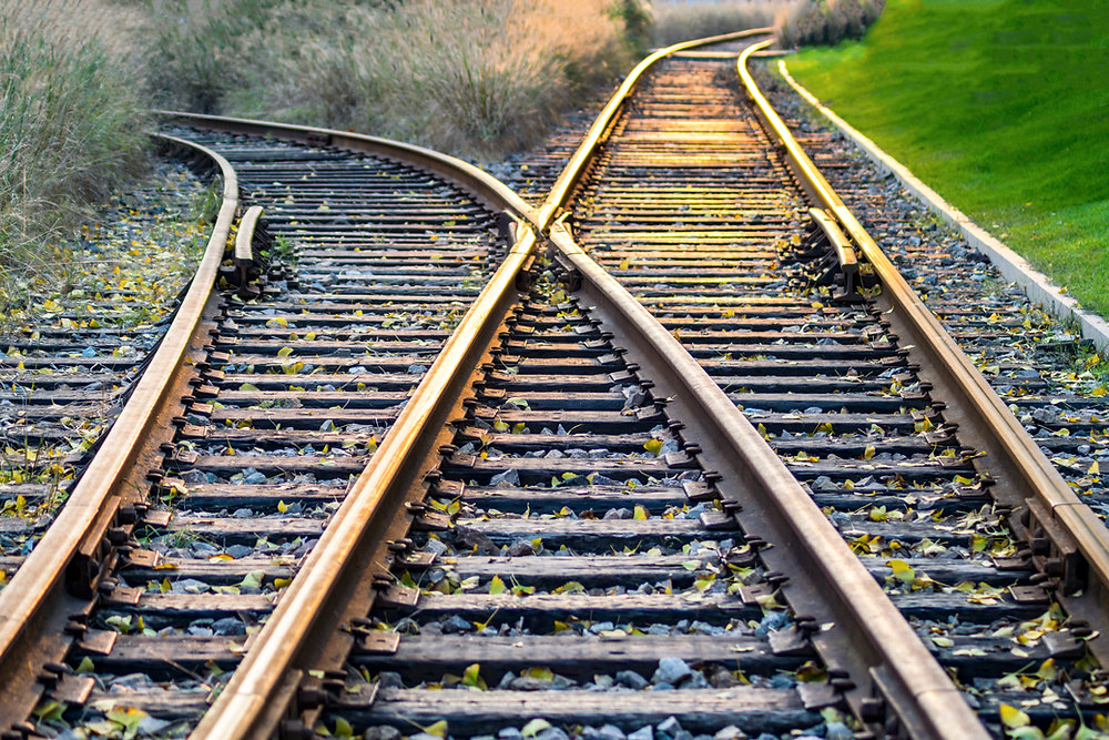 Railroad tracks diverging, the cover image for The Decision Kept Moving While We Built It