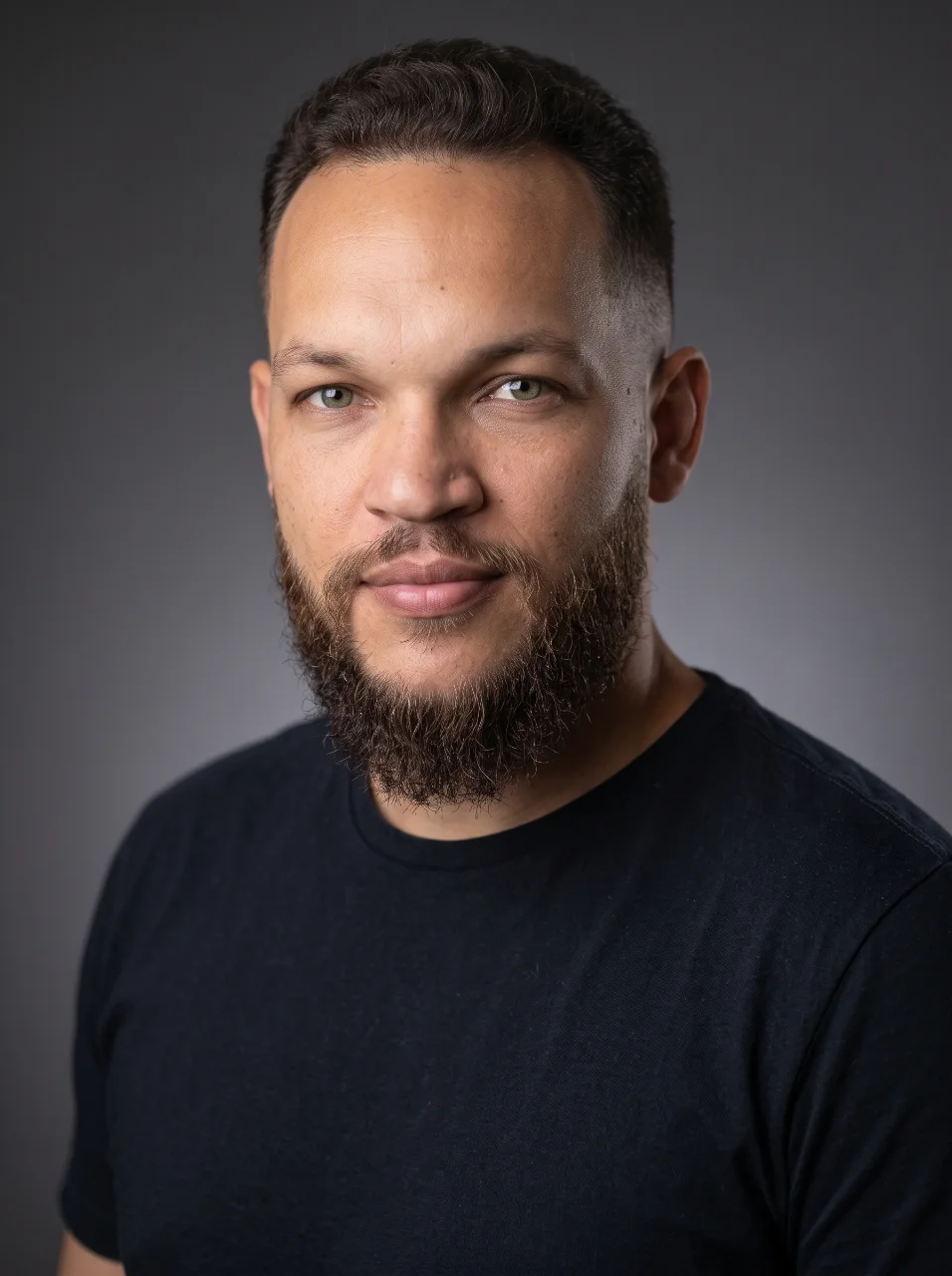 Studio portrait of Rodrigo Gonçalves in a black t-shirt against a plain grey background