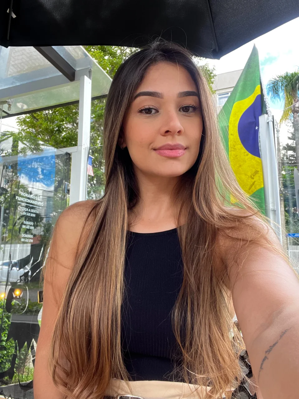 Portrait of Vanessa Cardoso in a black top, photographed outdoors under a parasol